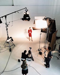 a woman is standing in front of a camera in a studio