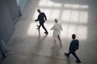 a group of business people walking in an office