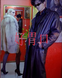 a man and woman in a fur coat standing in front of a mirror