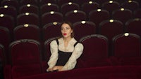 a woman sitting in an empty theater