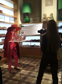 a woman in a red hat is being interviewed in a store