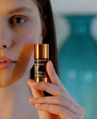 a woman is holding a tube of a product