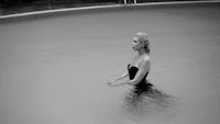 a black and white photo of a woman in a pool