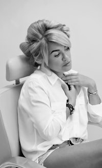 black and white photo of a woman sitting in a chair