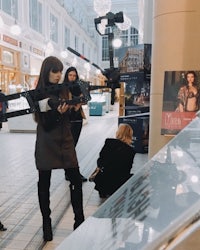 a group of people standing in a mall with a camera