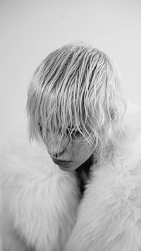 a black and white photo of a woman in a fur coat