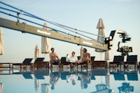 a group of people sitting around a pool with a camera